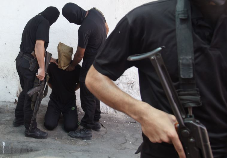 Hamas militants grab a Palestinian suspected of collaborating with Israel before being executed