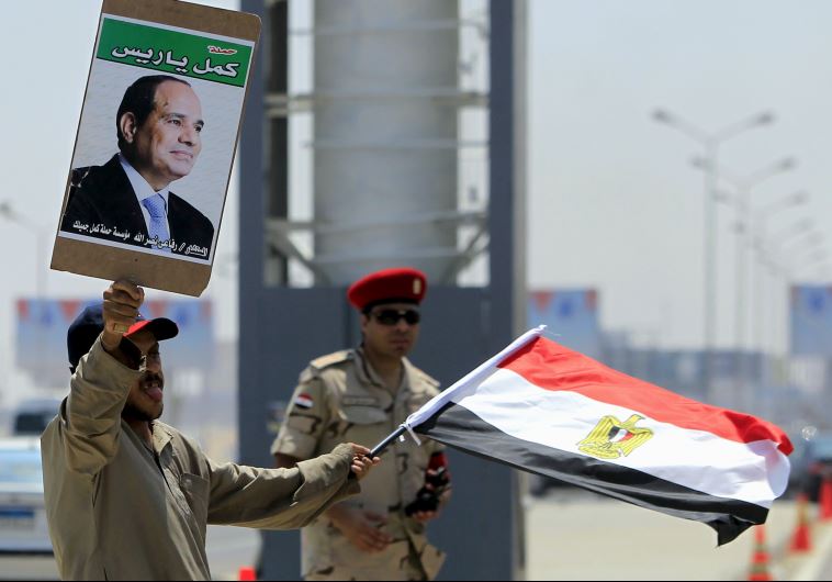 A man carrying a portrait of Egyptian President Abdel Fattah al-Sisi and an Egyptian flag