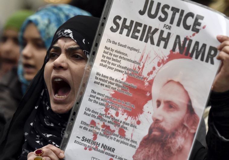 A protester holds a placard during a demonstration against the execution of Shi'ite cleric Sheikh Ni