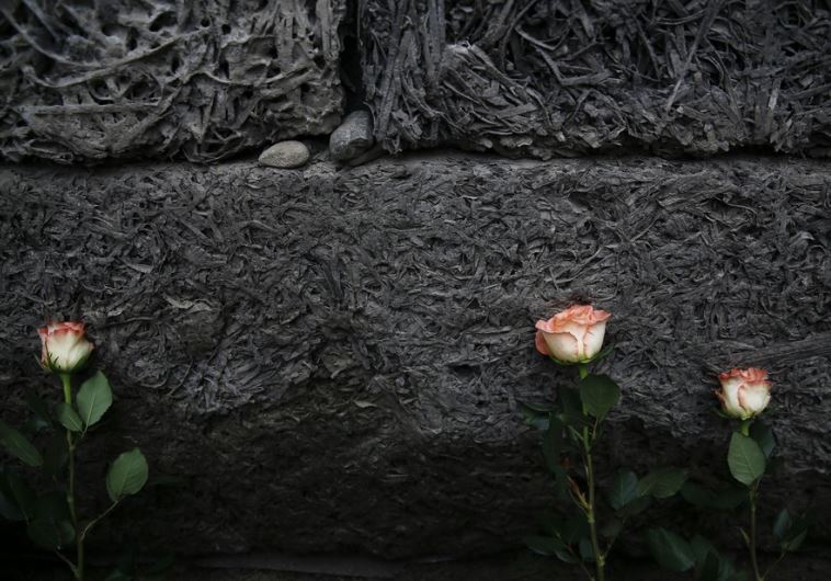 Flowers are placed at the "death wall" at Auschwitz