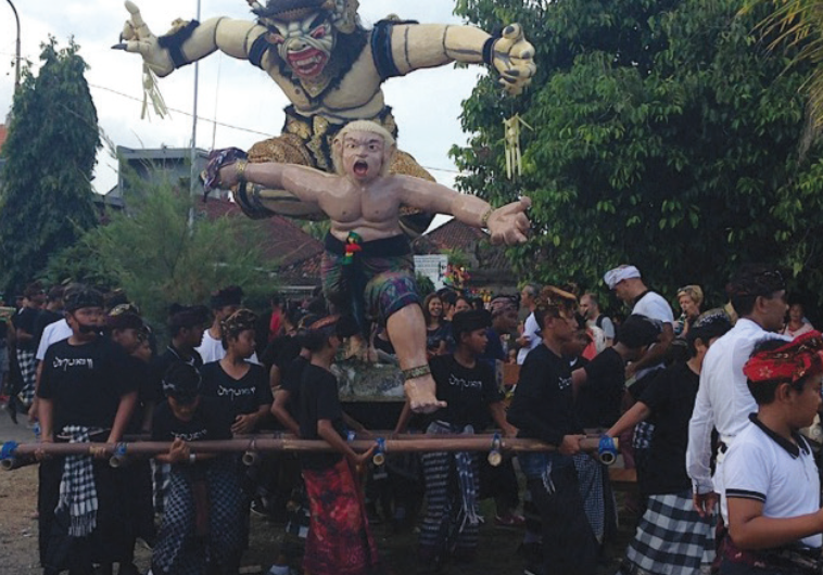 OGOH-OGOH, a towering effigy of demons and evil spirits, is carried down the street in Uluwatu.