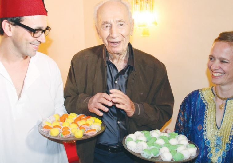 FORMER PRESIDENT Shimon Peres enjoys a post-Passover sweet at a Mimouna celebration in Tel Aviv.