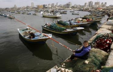 A Palestinian boy fishes at the Gaza Seaport