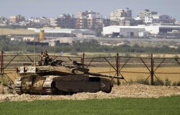 IDF soldier sits atop a tank just outside northern Gaza