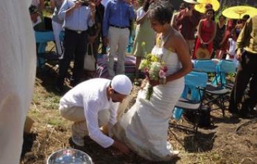 The groom washes the feet of his bride during the wedding