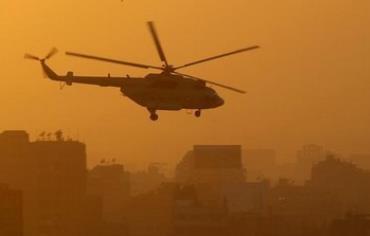 An Egyptian military helicopter flies during sunset over Tahrir Square.