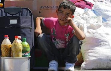 A Syrian boy sits beside his family's belongings after entering Turkey from Syria, Sept. 6, 2013. 