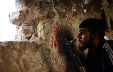 A Free Syrian Army fighter sits on a lookout for forces loyal to Assad September 8, 2013.