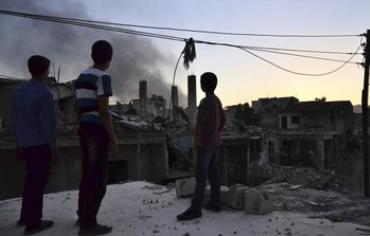Children are seen in front of rising smoke from what activists said was Free Syrian Army fighters 