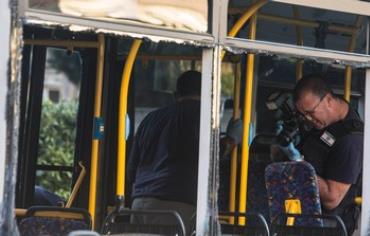 An Israeli police officer takes pictures inside a damaged bus at the scene of Bat Yam explosion