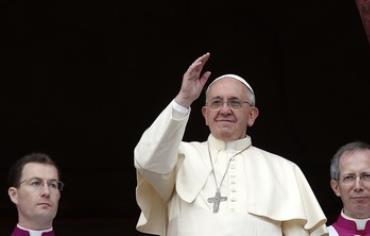 Pope Francis waves as he delivers his first "Urbi et Orbi"