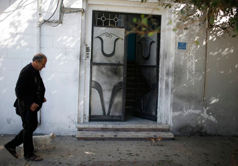 A man walks past a damaged door of a Fatah official's home after an explosion in Gaza City November 7, 2014 - Photo By: REUTERS