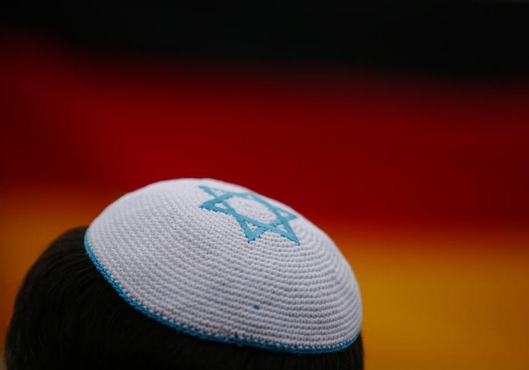 A man wearing a kippah listens to speakers during an anti-Semitism protest at Berlin's Brandenburg G