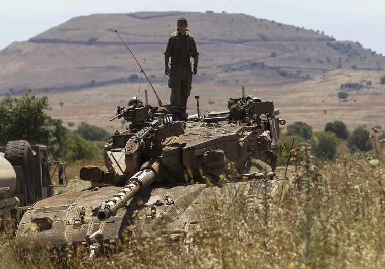 An IDF soldier stands atop a tank near Alonei Habashan on the Golan Heights, close to the ceasefire 