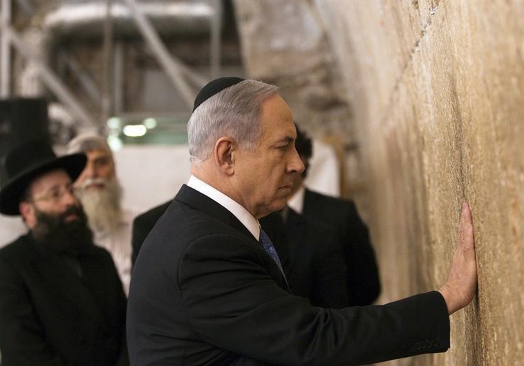 Prime Minister Benjamin Netanyahu touches the stones of the Western Wall