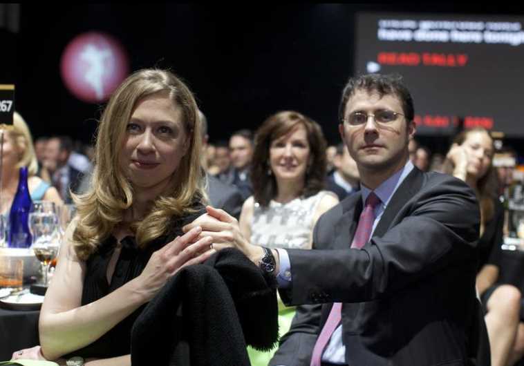Chelsea Clinton and her husband Marc Mezvinsky (R) sit in the audience at the Robin Hood Foundation 