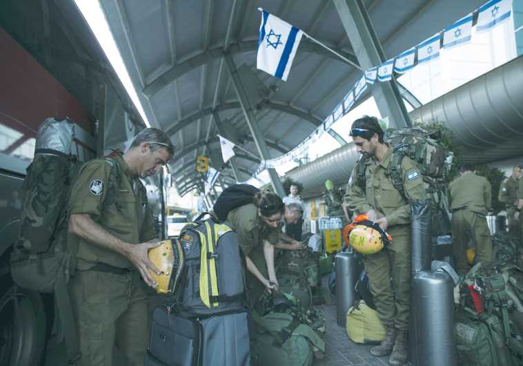 Members of an IDF aid delegation prepare their equipment as they wait for a flight to Nepal