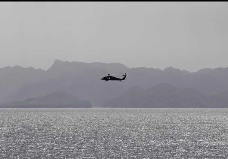 A helicopter patrols the Strait of Hormuz