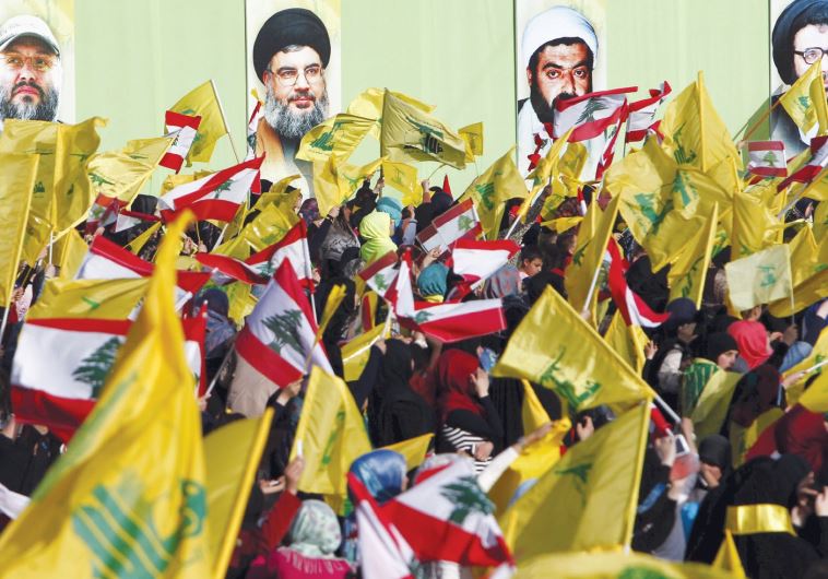 LOCALS IN NABATIYA, south Lebanon, carry Hezbollah and Lebanese flags