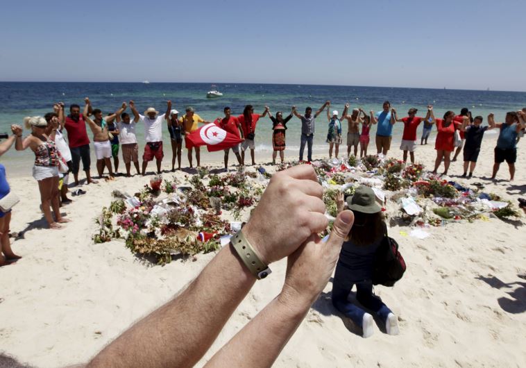 People join hands as they observe a minute's silence in memory of those killed in Tunisia