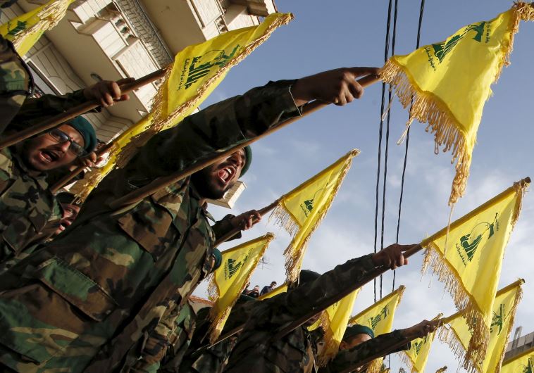 Lebanon's Hezbollah members carry Hezbollah flags during the funeral of Adnan Siblini