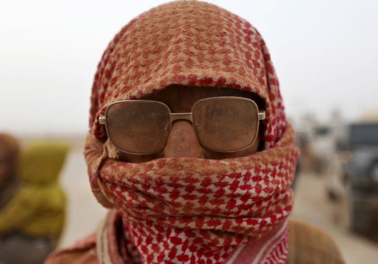A Syrian refugee man covered with dust arrives at the Trabeel border, after he crossed into Jordan