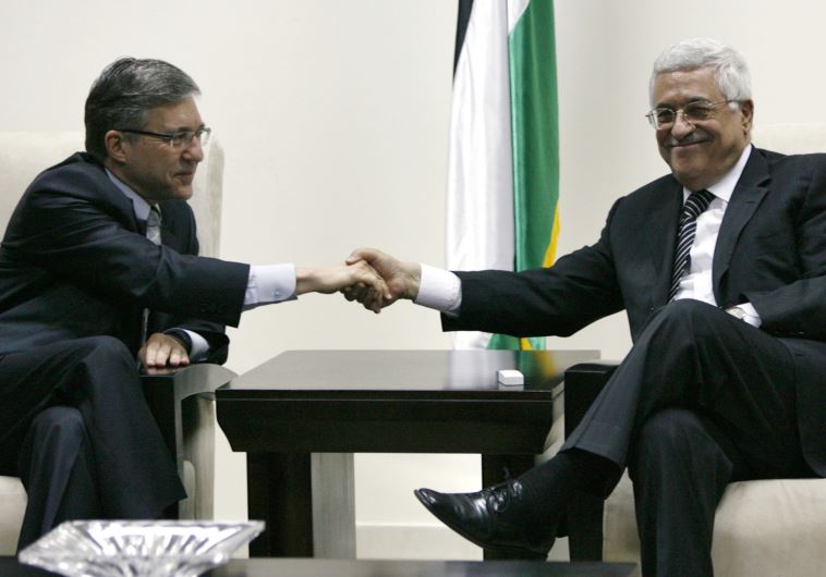 Palestinian Authority President Mahmoud Abbas (R) shakes hands with ex-justice minister Yossi Beilin