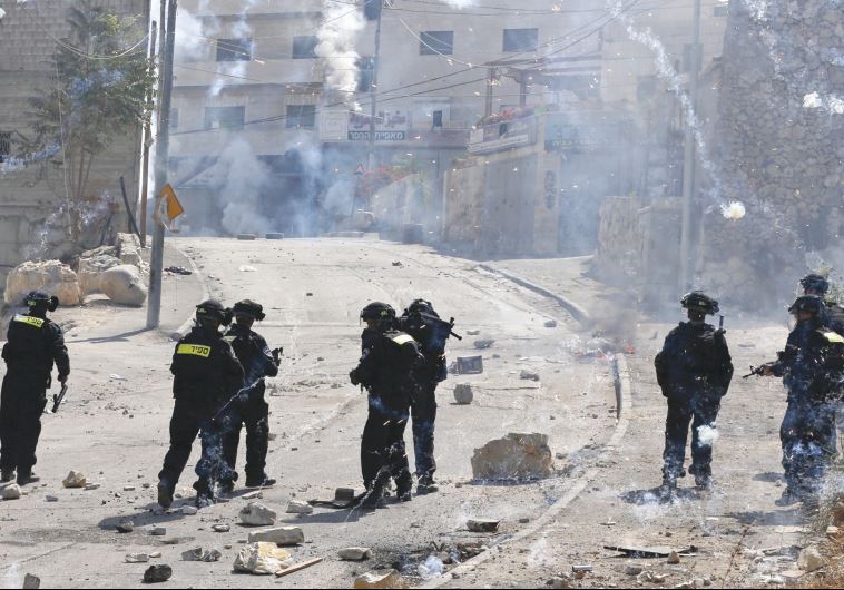 FIREWORKS FALL near policemen during clashes in the capital’s Isawiya neighborhood
