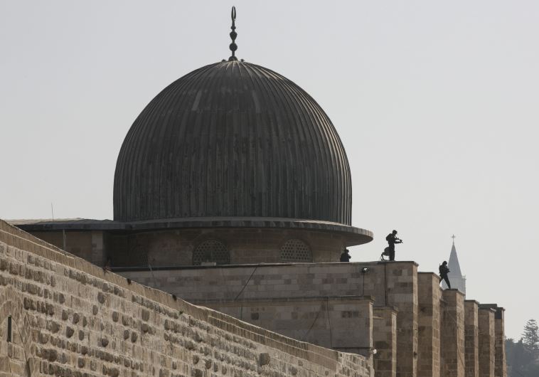 Israeli police officers take positions on the roof of the al-Aksa mosque