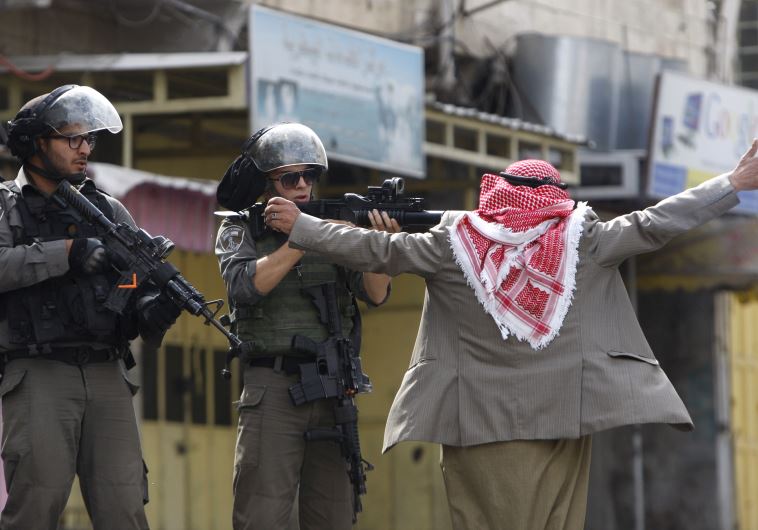 An old Palestinian man prevents Border Policemen from shooting at protesters in Hebron