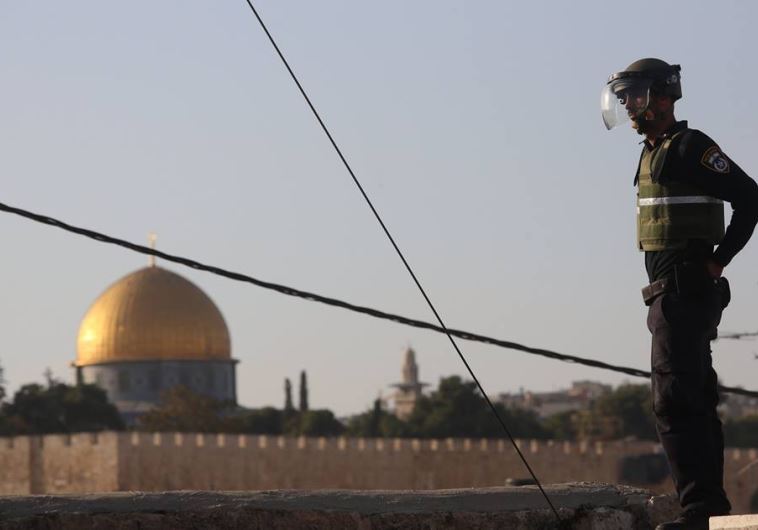 A Border Police officer overlooks Temple Mount and the Western Wall