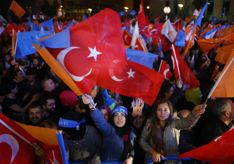 Women wave flags outside the AK Party headquarters in Ankara, Turkey