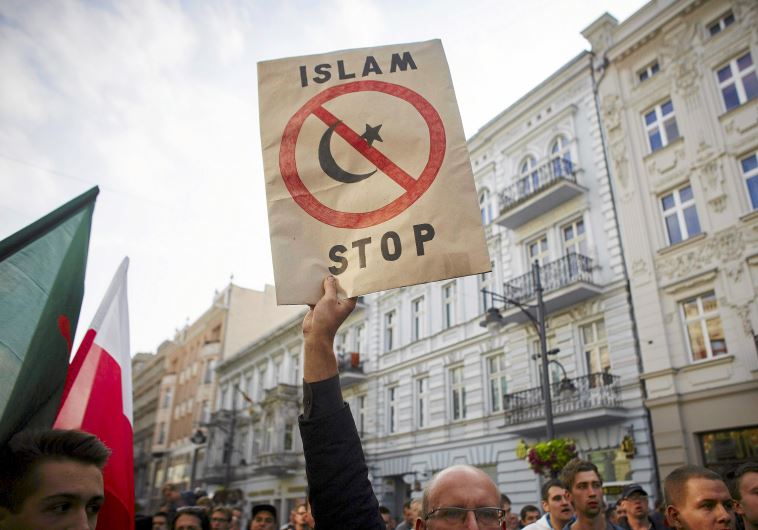 A protester from a far-right organization holds up a sign which reads "Islam Stop" during a protest