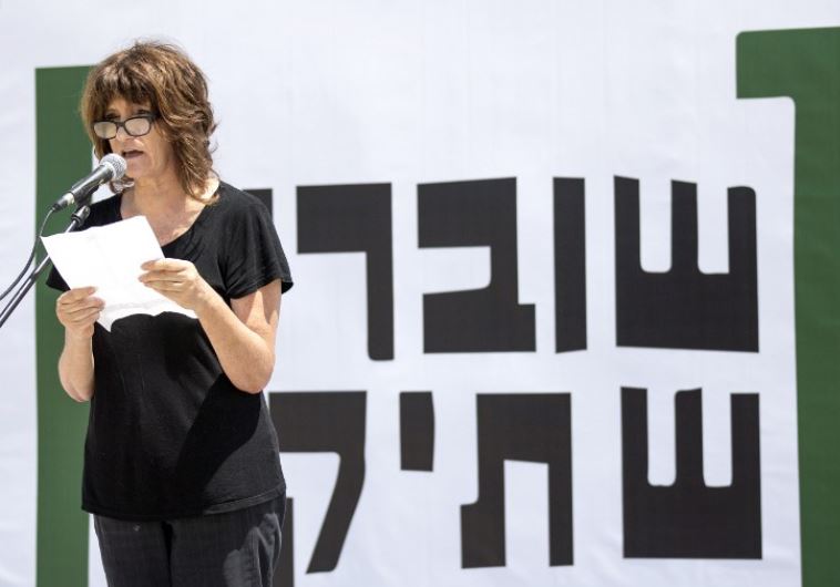 A woman reads testimonies during a gathering in Tel Aviv