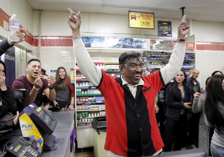 7-Eleven store clerk M. Faroqui celebrates after selling a winning Powerball ticket in Chino Hills