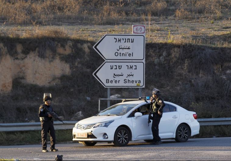 Israeli policemen stand near a checkpoint close to the West Bank settlement of Otniel