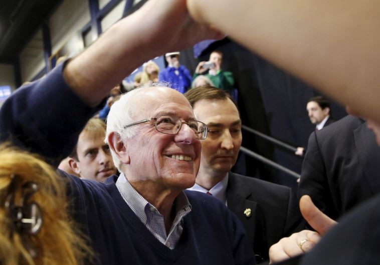 Democratic US presidential candidate Bernie Sanders shakes hands with supporters during a rally 