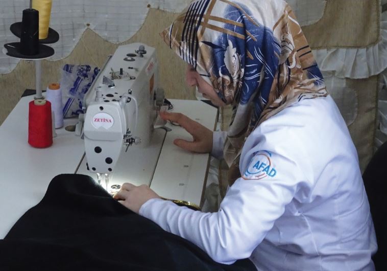 A WOMAN works at a sewing station in the Oncupinar refugee camp near Kilis.