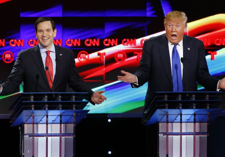Republican US presidential candidates Marco Rubio (L) and Donald Trump speak simultaneously at the d