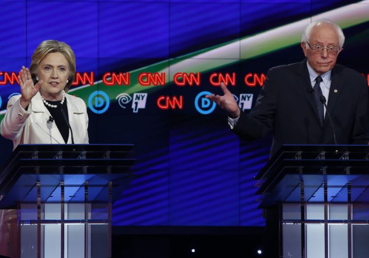 Democratic U.S. presidential candidate Hillary Clinton (L) speaks as Senator Bernie Sanders reacts d