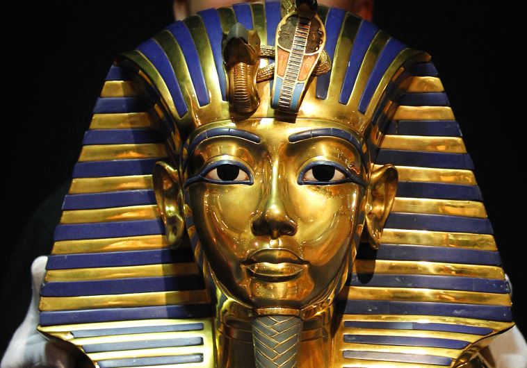 A worker shows to media a replica of a golden death mask of Pharaoh Tutankhamun