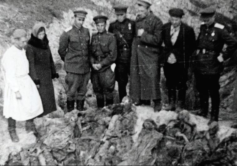 SOVIET SOLDIERS stand by a mass grave in Lyady, Belarus, in 1943.