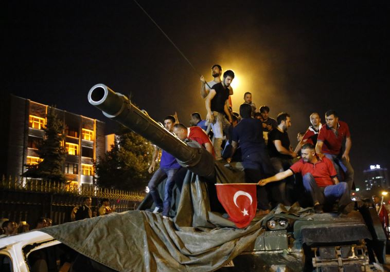 People stand on a Turkish army tank in Ankara, Turkey July 16, 2016