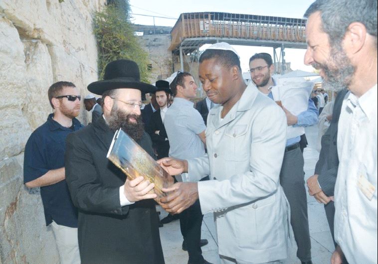 TOGO PRESIDENT Faure Gnassingbe receives a book from Rabbi Shmuel Rabinowitz during a visit to the W