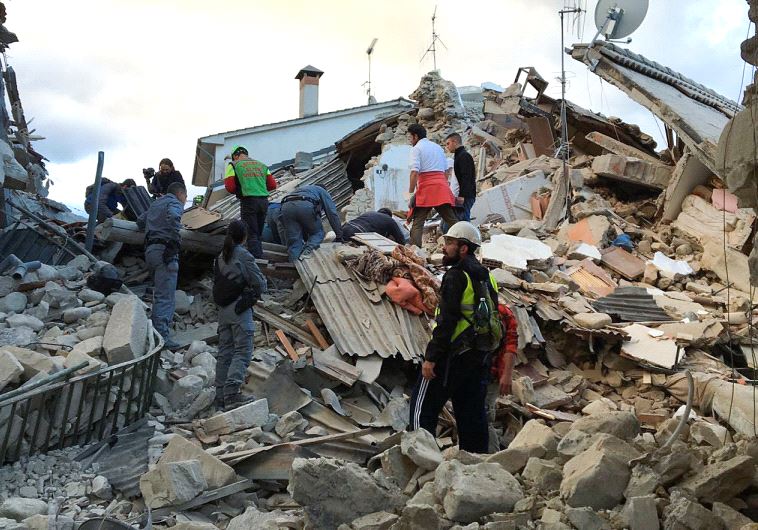 Rescuers work at a collapsed house following a quake in Amatrice, central Italy, August 24, 2016.