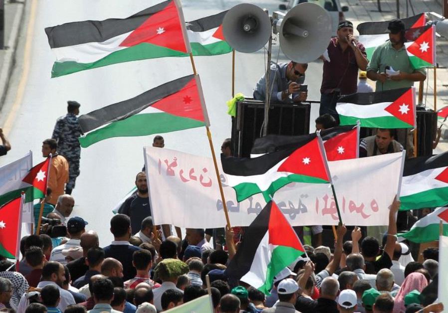 PROTESTERS IN Jordan hold Jordanian and Palestinian flags as they march in protest against Israel.