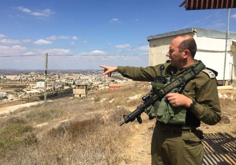 Lt Col Tsafrir Harshoshanim points at Palestinian villages west of Hebron