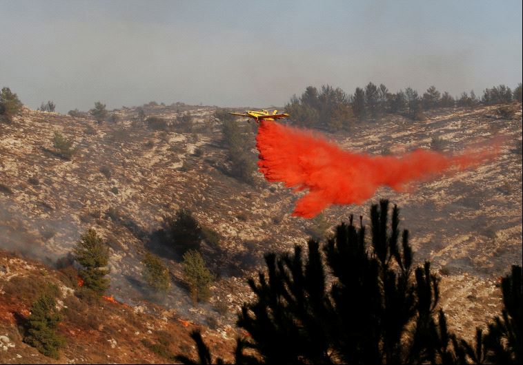 Um avião de combate a incêndios deixa cair o fogo-retardador durante um incêndio, perto do assentamento comunal de Nataf, perto de Jerusalém 23 de novembro de 2016. (Reuters)