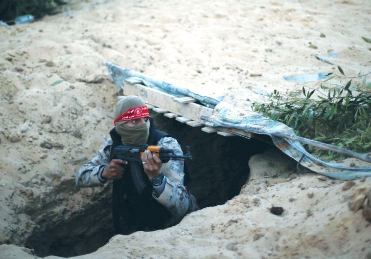 A PALESTINIAN TERRORIST climbs out of a tunnel in the Gaza Strip during a graduation ceremony in Raf