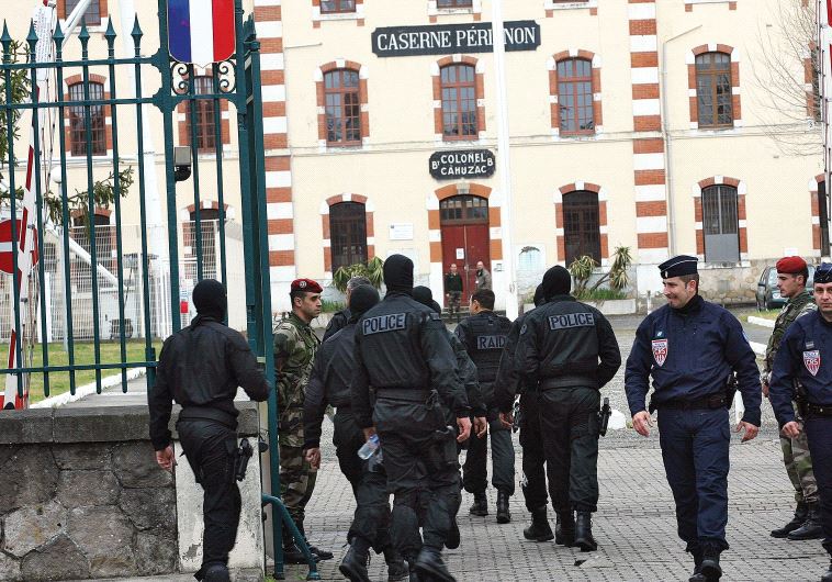 MASKED FRENCH special unit policemen arrive at Perignon barracks after tracking down a terrorist in 